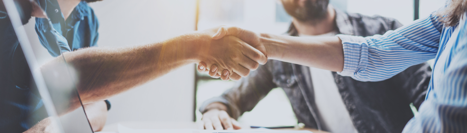 Business partnership handshake concept.Photo two coworkers handshaking process.Successful deal after great meeting.Horizontal, blurred background.Wide.